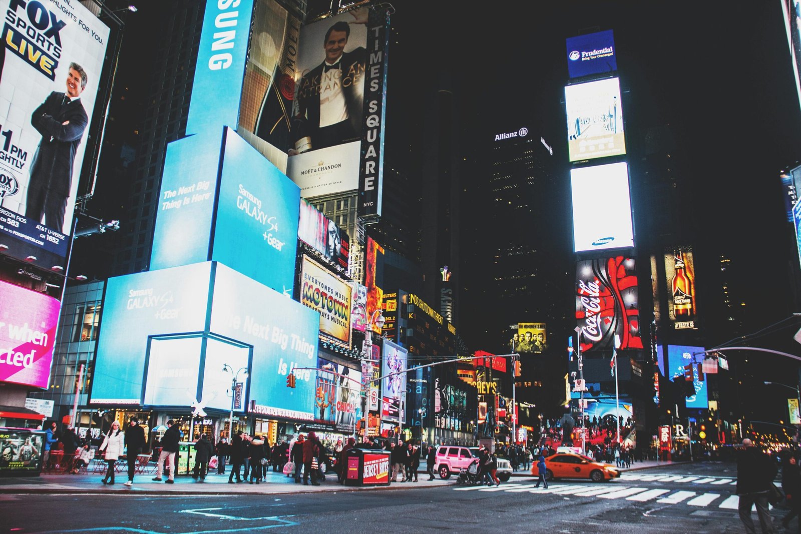 Dynamic night scene with neon lights and bustling crowds in Times Square, New York City.